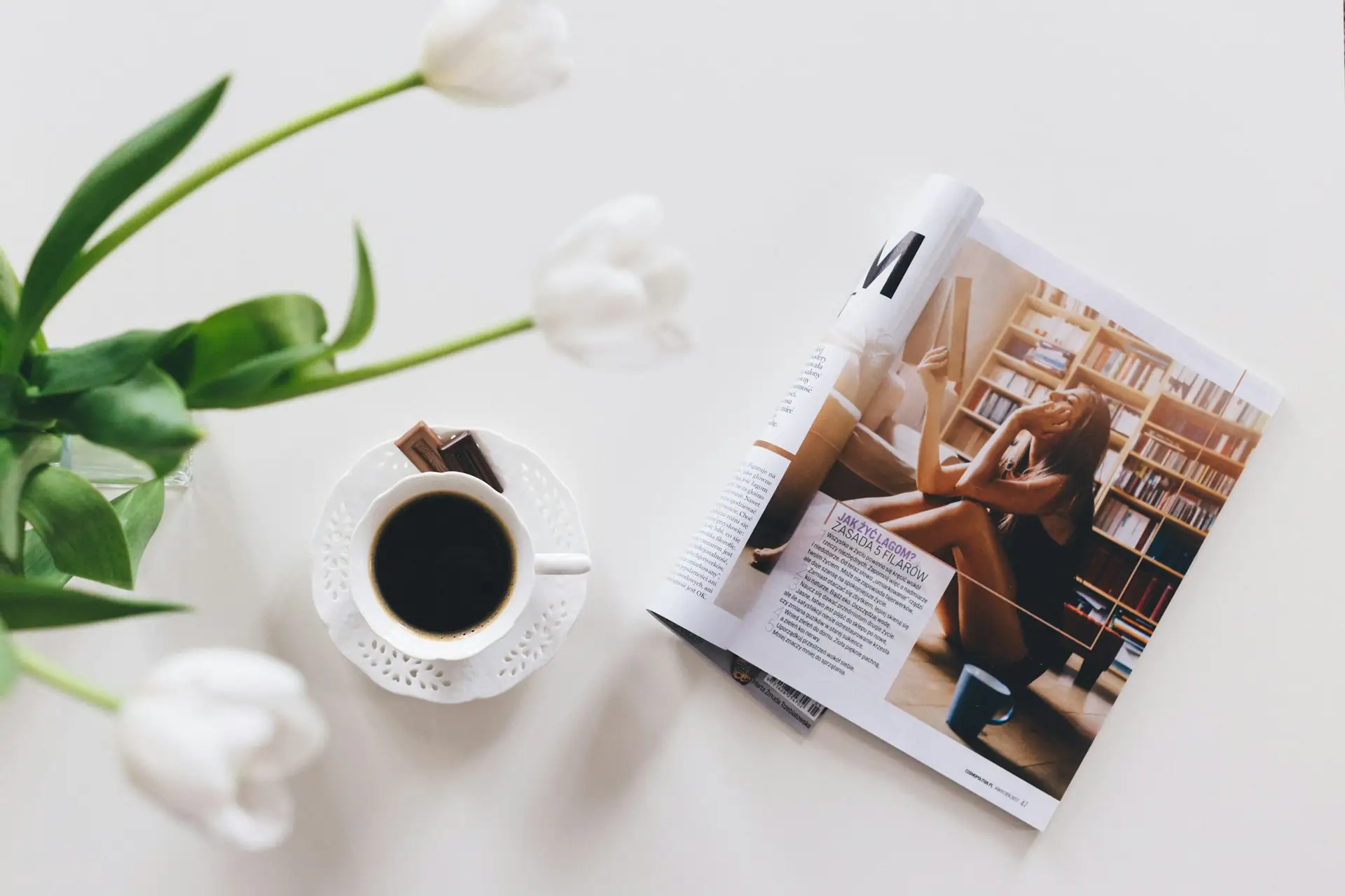 Revista oberta al costat d’una tassa de cafè